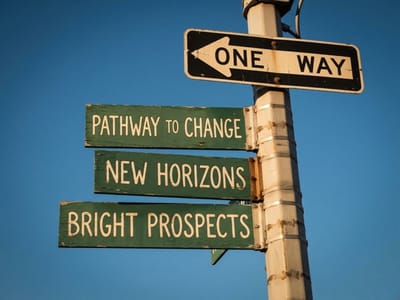 Signpost with green signs reading Pathway to Change, New Horizons and Bright Prospects