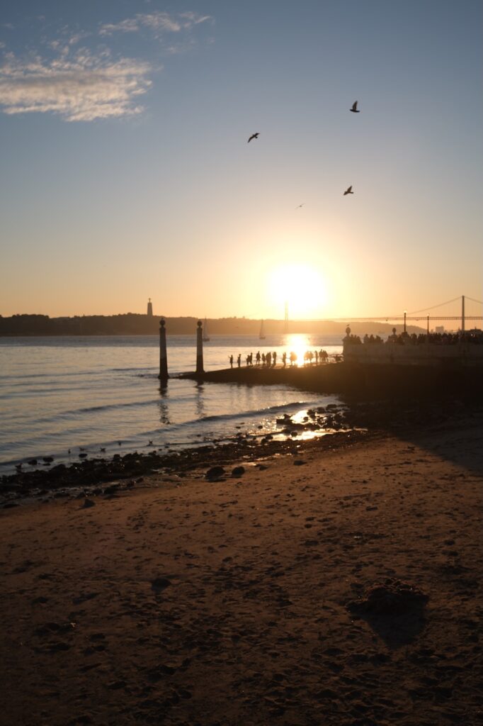 Sunset over the water along a rocky coastline.